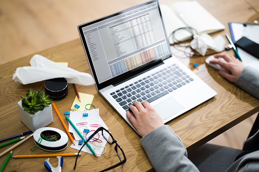 An office worker sitting at a desk with a lot of clutter and needing professional cleaning services in St. Charles, MO.