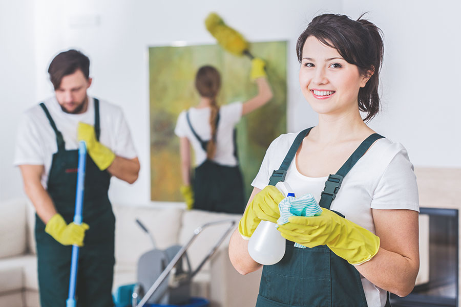 A team of three residential cleaning maids in St. Charles, MO that is sweeping, dusting, and wiping down the surfaces of a home.