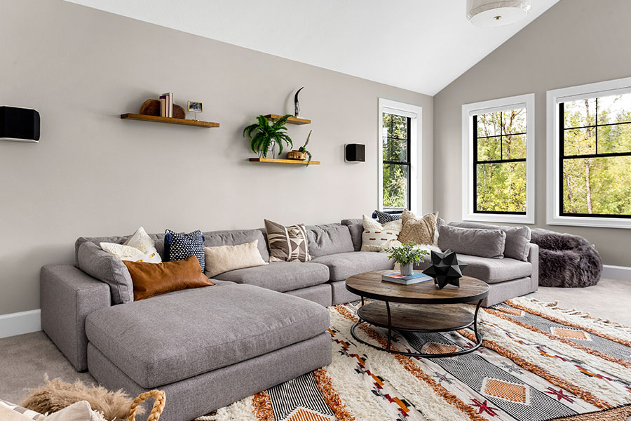 A clean living room with a grey couch and modern décor in St. Charles, MO that has been kept tidy with tips from our expert maids.