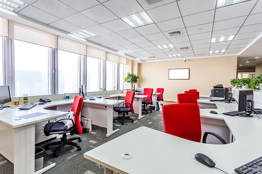 A clean office in St. Charles, MO, with spotless red chairs and white desks thanks to a janitorial cleaning service for your business.