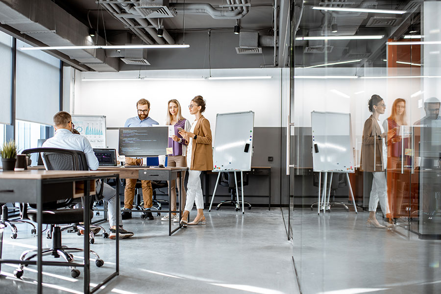 A modern office with four employees working in a small and clean space thanks to a professional maid cleaning service in Maryland Heights, MO, which boosted their work productivity.